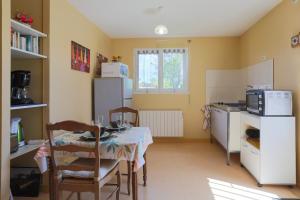 a kitchen with a table with chairs and a refrigerator at Gîte Proche Mer 800 m in Plouézec