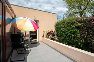 a patio with a table and a colorful umbrella at Gîte Proche Mer 800 m in Plouézec