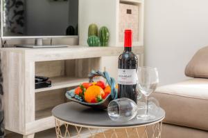 a bottle of wine and a bowl of fruit on a table at Finca el Cactus in Can Picafort +17 photos