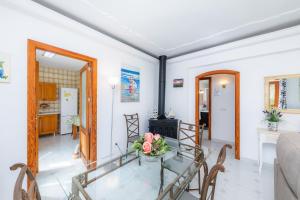a dining room and living room with a glass table at Finca el Cactus in Can Picafort