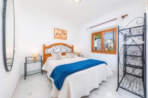 a white bedroom with a bed and a window at Finca el Cactus in Can Picafort