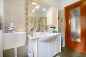 a white bathroom with a sink and a mirror at Casa Vacanze Gianluca in Aosta +24 photos