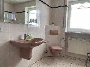 a bathroom with a sink and a toilet at Ferienwohnung Heilsbronn in Heilsbronn +17 photos