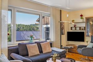 a living room with a couch and a large window at Ferienwohnung Fuldatalblick in Fulda