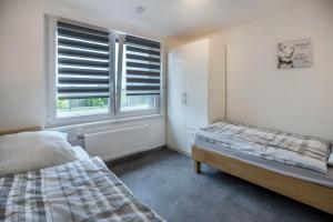 a bedroom with two beds and a window with blinds at Ferienwohnung 9 und 40 in Thunum
