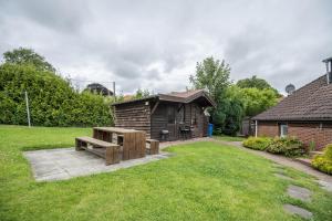 a wooden cabin with a bench in the grass at Ferienwohnung 9 und 40 in Thunum