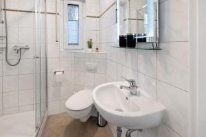 a white bathroom with a sink and a toilet at Ferienwohnung Fuldatalblick in Fulda +24 photos