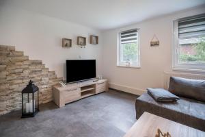 a living room with a flat screen tv on a wooden cabinet at Ferienwohnung 9 und 40 in Thunum