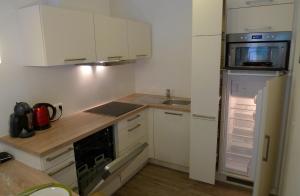 eine kleine Küche mit weißen Schränken und einem Kühlschrank in der Unterkunft Ferienwohnung Loitfelder-Pang in Saalbach-Hinterglemm