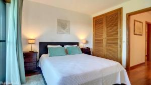 a bedroom with a large white bed with blue pillows at Arrancada 14 in Pêra +28 photos