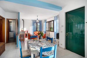 a dining room with a table and a green door at Villa Bella Vista in Imperia