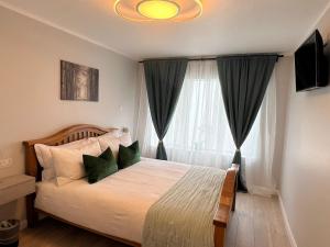 a bedroom with a bed with green pillows and a window at Private Entrance En-suite in Gorey