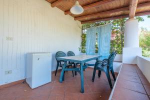 a blue table and chairs on a patio with a window at Jera suite vista mare 2 in Vulcano +19 photos