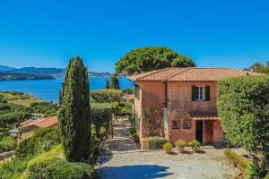 a house on a hill with a view of the water at Villa Les Ombrelles in Portoferraio
