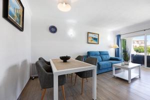 a living room with a table and a blue couch at Apartamento Navegador in Sagres