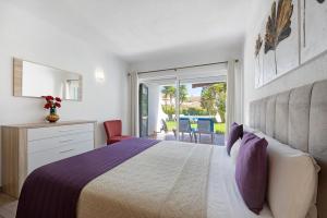 a bedroom with a bed and a balcony with chairs at Apartamento Navegador in Sagres +13 photos