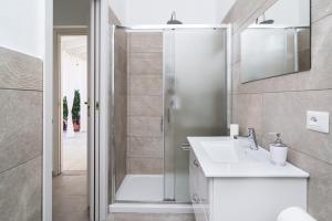 a bathroom with a shower and a white sink at Domo Bonaeras in Irgoli