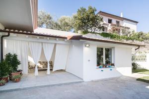 a white house with white curtains on it at Domo Bonaeras in Irgoli