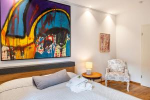 a bedroom with a bed and a chair and a painting at Ferienwohnung Ederweg in Wahlershausen
