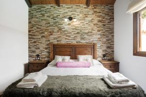 a bedroom with a large bed with a brick wall at Villa Africa in La Muela +18 photos