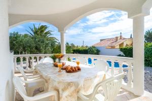 a white table with a bowl of food on a balcony at Villa Flor in Les tres Cales