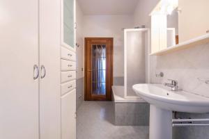 a white bathroom with a sink and a mirror at Casa Vacanze Matisse in Toscolano Maderno +23 photos