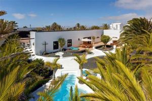 an aerial view of a villa with a swimming pool and palm trees at Villa El Cactus in Teguise