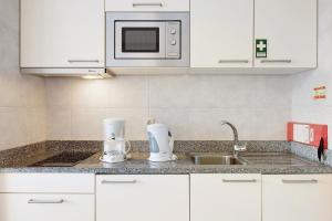 a kitchen counter with a sink and a microwave at Dfm Happy Days C - Funchal in Funchal +7 photos