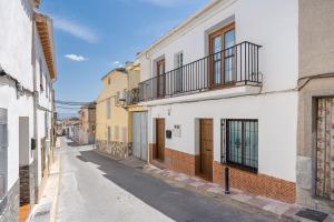 an empty street in an alley with buildings at Casa Petra in Illora