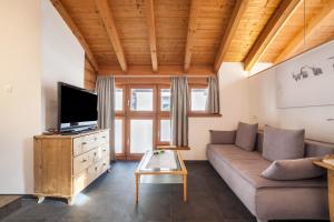 a living room with a couch and a tv at Ferienwohnung Burgeis in Malles Venosta