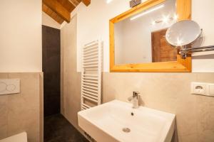a bathroom with a sink and a mirror at Ferienwohnung Burgeis in Malles Venosta +12 photos