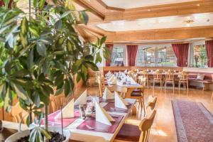 a restaurant with tables and chairs and a potted plant at Haus Steinatal in Ühlingen-Birkendorf
