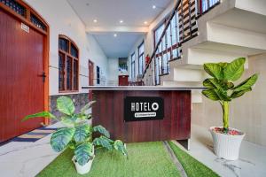 a school hallway with two plants in a building at Super Hotel O Raj Ghat Ayodhya Formerly Shree Siya Raman in Ayodhya