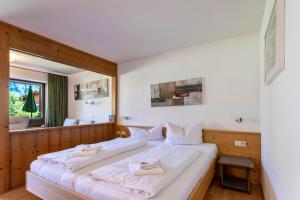 a bedroom with a large bed with white sheets at Studio Bergblick in Inzell