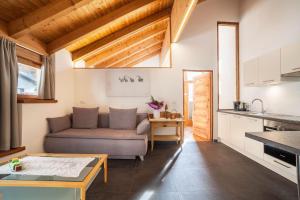 a living room with a couch and a kitchen at Ferienwohnung Burgeis in Malles Venosta