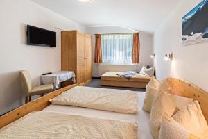 a hotel room with two beds and a flat screen tv at Ferienwohnung Helena in Schwendau
