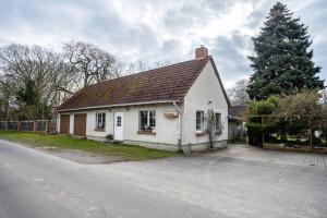 a small white house on the side of a road at Ferienwohnung Kropp in Knorrendorf