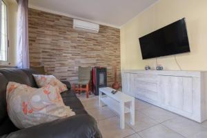 a living room with a couch and a flat screen tv at Casa a 100 mt Dal Mare in SantʼAlessio Siculo