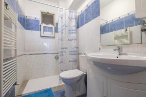 a blue and white bathroom with a sink and a toilet at Casa a 100 mt Dal Mare in SantʼAlessio Siculo +13 photos