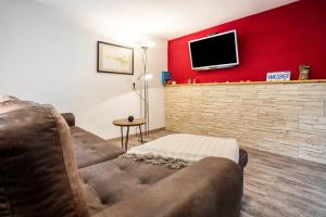 a living room with a couch and a tv on a red wall at Ferienwohnung Kropp in Knorrendorf