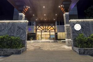 a lobby of a building with a clock on the wall at Hotel Nivaara By VYDA in Tirupati