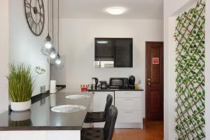 a kitchen with a counter and a table with chairs at Apartamento Lolita com Terraço in Caniço +14 photos