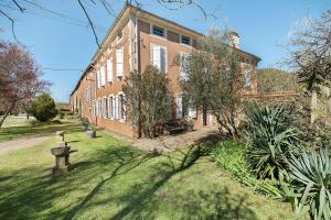 a large brick building with trees in front of it at Chambres D'hôtes - Le Marlas in Rieucros