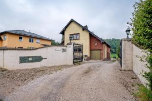 a house on a dirt road next to a fence at Ferienwohnung in der Eifel in Pesch
