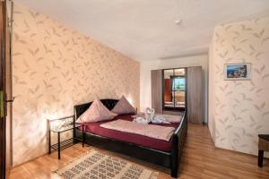 a bedroom with a bed with a red bedspread at Ferienwohnung in der Eifel in Pesch