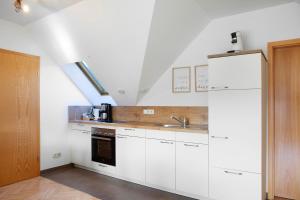 a kitchen with white cabinets and a sink at Ferienwohnung Tannenblick 7-5 in Oberhof +6 photos