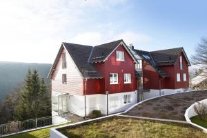 a house with red and white houses on a hill at Ferienwohnung Tannenblick 7-5 in Oberhof