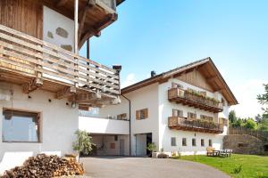 a house with white walls and wooden roof at Stinerhof Panoramablick in Vols am Schlern