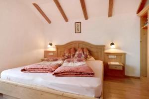 a bedroom with a white bed with two pillows at Stinerhof Panoramablick in Vols am Schlern