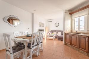 a kitchen and dining room with a table and chairs at Apartamento San Juan 18 in Nerja